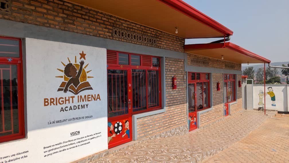 Le bâtiment des classes, avec le logo et la vision de Bright IMENA Academy peints sur le mur