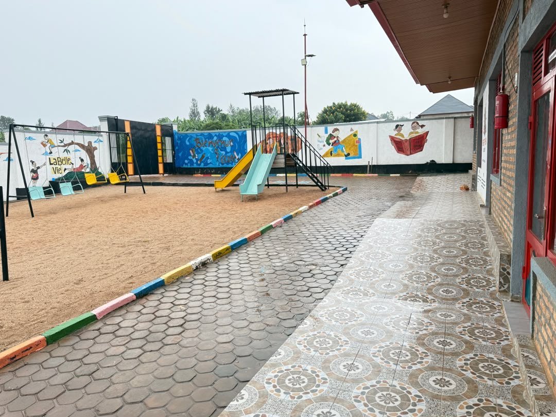 La cour de récréation et l'allée pavée le long des classes